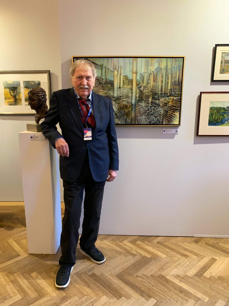 Künstlergenossenschaft München: MKG-Ausstellung 2025. Der Künstler Radu-Anton Maier vor seinem Werk „Säkulare Ruinen“, Mischtechnik auf Leinwand, 100 x 60 cm, 2015