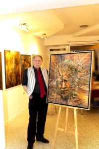 Radu Maier mit seinem Selbstbildnis bei der Ausstellung mit Gemälde und Portraits